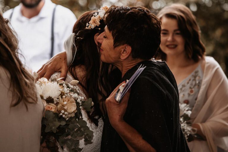 Ein Bild in Murnau, eine emotionale Umarmung nach der Trauung, man sieht einen Blumenstrauß, ein sehr emotionaler Moment