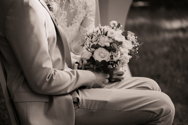 Schwarz-Weiß-Aufnahme eines Brautpaars während der Trauung in Garmisch-Partenkirchen – die Braut hält einen Blumenstrauß, emotionaler Moment im Standesamt festgehalten in zeitloser Hochzeitsfotografie.